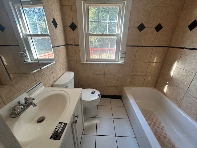 bathroom with toilet, tile patterned flooring, a bathtub, tile walls, and vanity