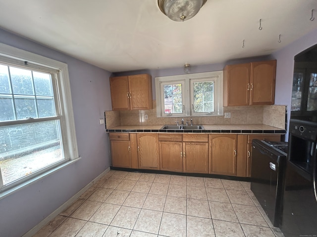 kitchen featuring tasteful backsplash, plenty of natural light, and tile counters