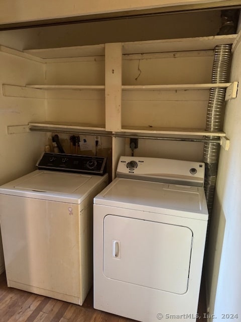 clothes washing area featuring independent washer and dryer and hardwood / wood-style flooring