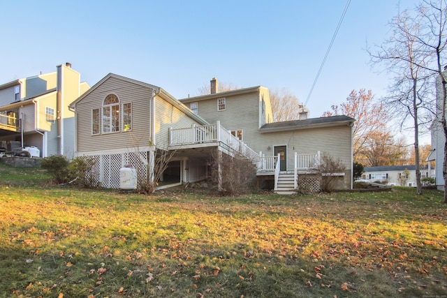 rear view of property featuring a deck and a lawn