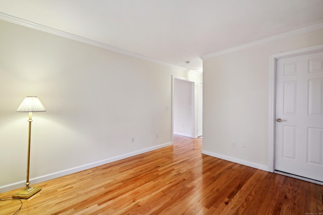 empty room featuring crown molding and hardwood / wood-style flooring