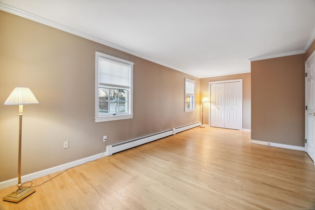 spare room with crown molding, light hardwood / wood-style floors, and baseboard heating