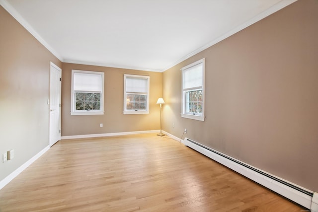 unfurnished room featuring ornamental molding, plenty of natural light, light hardwood / wood-style flooring, and a baseboard heating unit