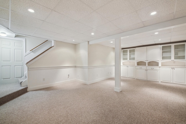 basement with carpet floors and a drop ceiling