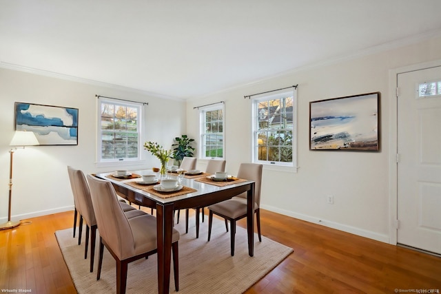 dining room with crown molding and light hardwood / wood-style flooring