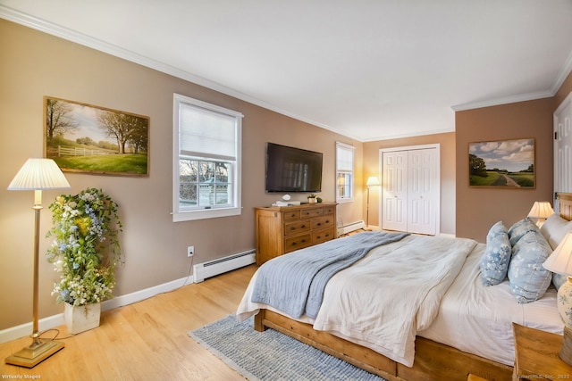 bedroom with a baseboard heating unit, crown molding, a closet, and light wood-type flooring