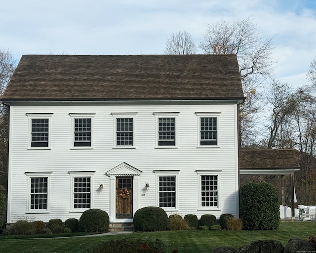 colonial inspired home featuring a front lawn