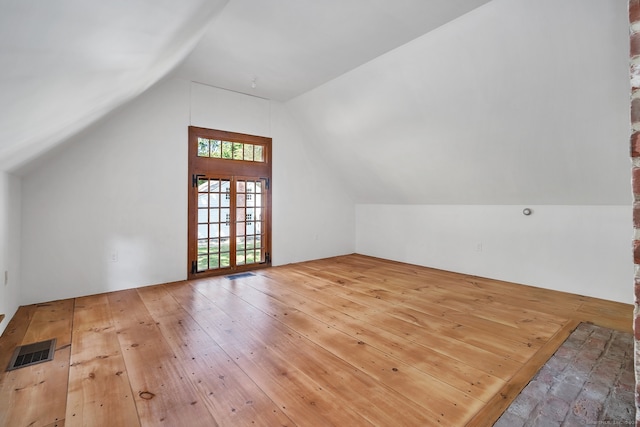 bonus room featuring lofted ceiling, french doors, and wood-type flooring