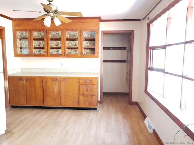 kitchen featuring ornamental molding, light wood-type flooring, and ceiling fan