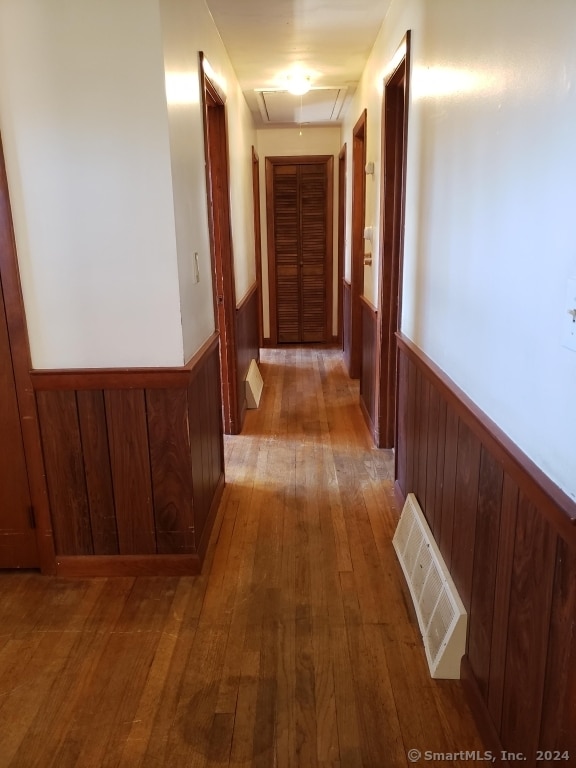 corridor featuring wood walls and light wood-type flooring