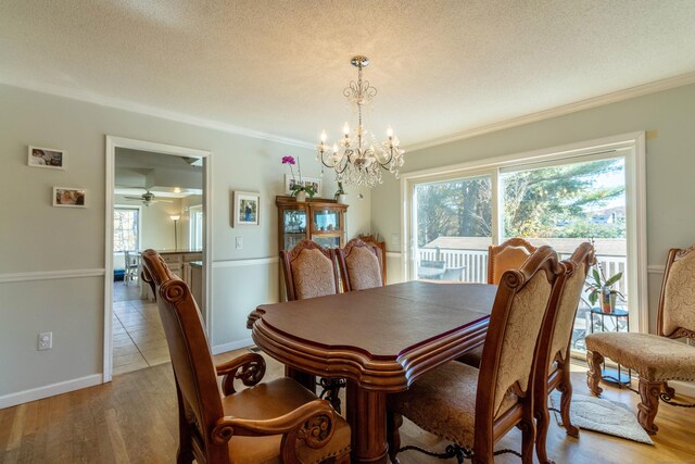 dining room featuring ceiling fan with notable chandelier, wood-type flooring, a textured ceiling, and ornamental molding