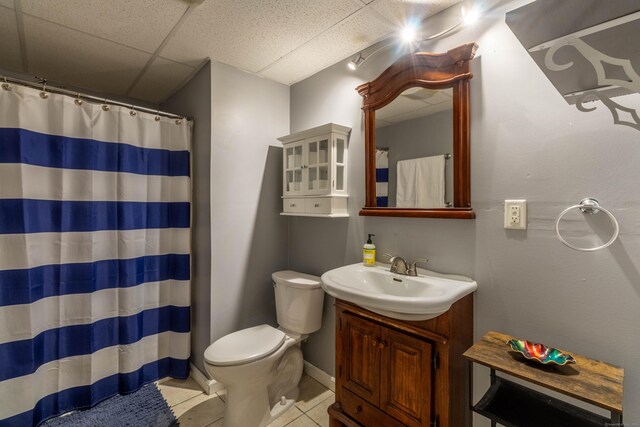 bathroom with a paneled ceiling, vanity, tile patterned floors, a shower with curtain, and toilet