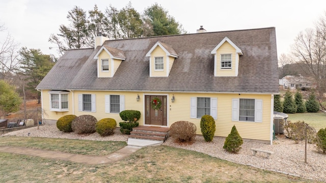 cape cod-style house with central AC unit and a front lawn