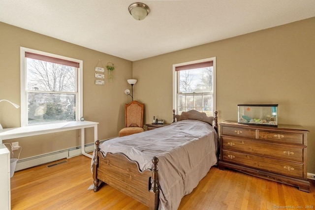 bedroom featuring a baseboard radiator and light hardwood / wood-style flooring