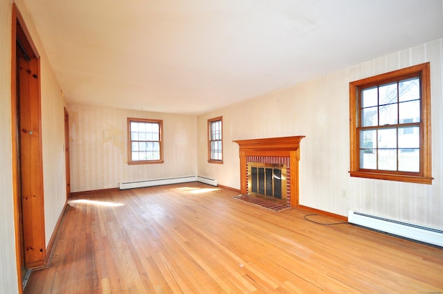 unfurnished living room with a brick fireplace, light wood-style flooring, baseboards, and baseboard heating