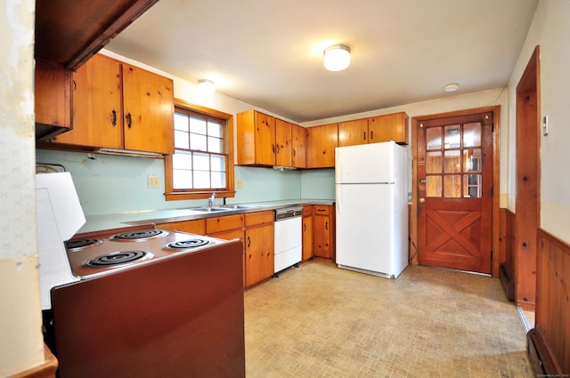 kitchen with brown cabinets, a sink, white appliances, a baseboard radiator, and light floors