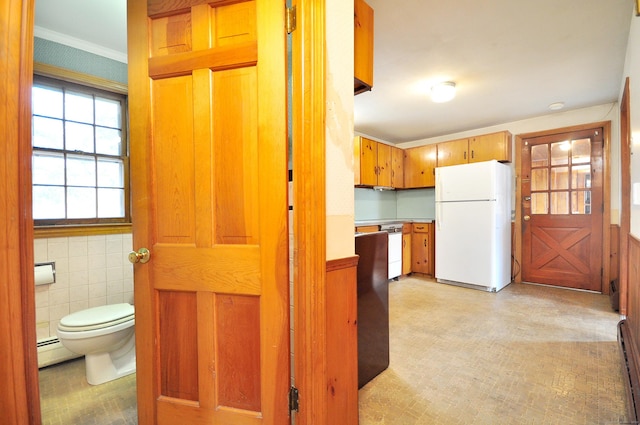 interior space featuring a baseboard heating unit, light floors, ornamental molding, baseboard heating, and tile walls