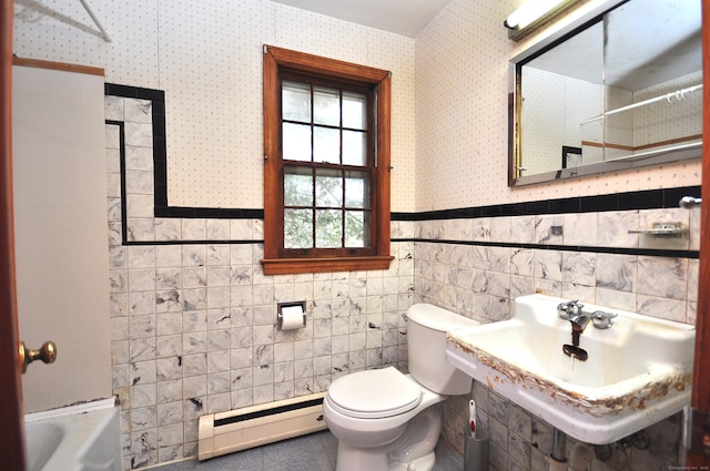 bathroom featuring toilet, a sink, a baseboard heating unit, wainscoting, and wallpapered walls