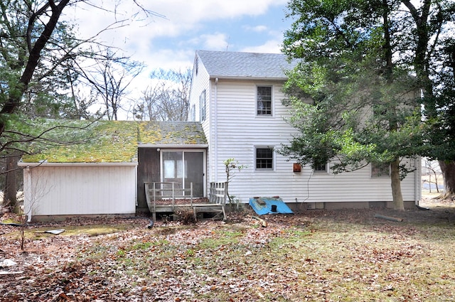 back of house with a shingled roof