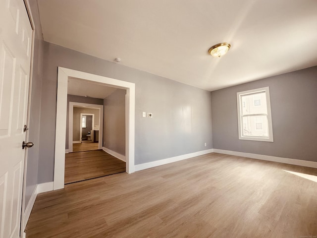 empty room featuring light wood-style floors and baseboards