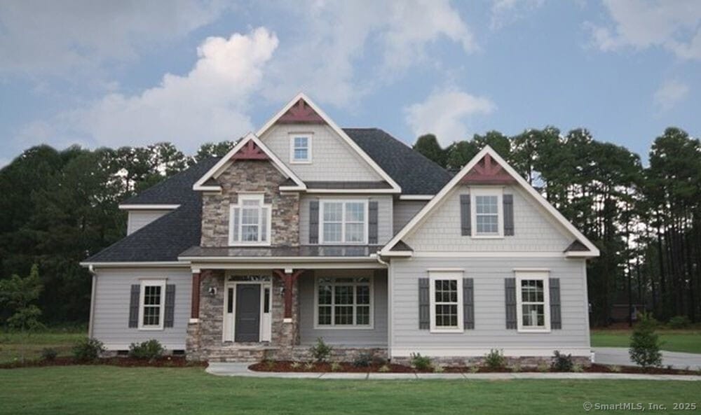 craftsman inspired home with a front lawn, covered porch, and stone siding