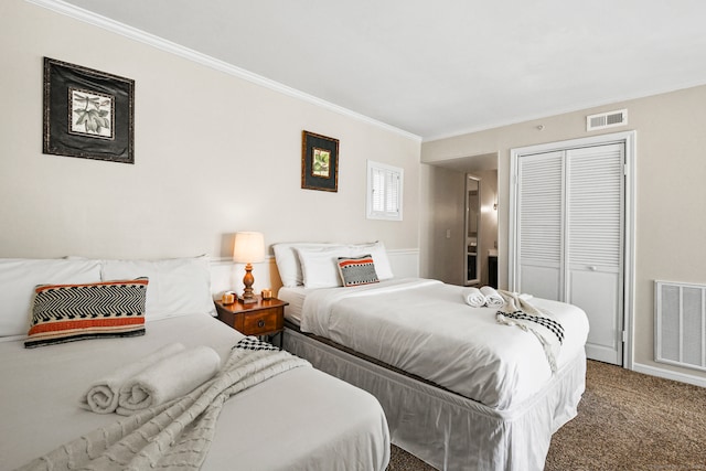 carpeted bedroom with crown molding and a closet