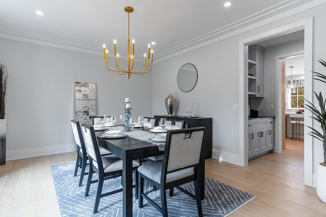 dining room featuring crown molding, a notable chandelier, light wood-type flooring, and built in shelves