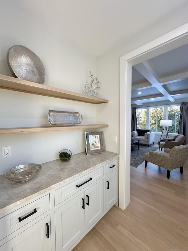 bar featuring coffered ceiling, beam ceiling, white cabinets, and light wood-type flooring