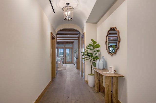 hallway with beamed ceiling and light hardwood / wood-style floors