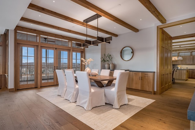 dining room featuring beamed ceiling and light hardwood / wood-style floors