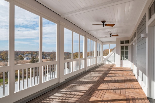 unfurnished sunroom with wood ceiling, ceiling fan, and beam ceiling