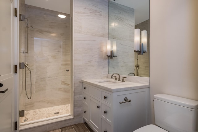 bathroom with vanity, a shower with shower door, and toilet