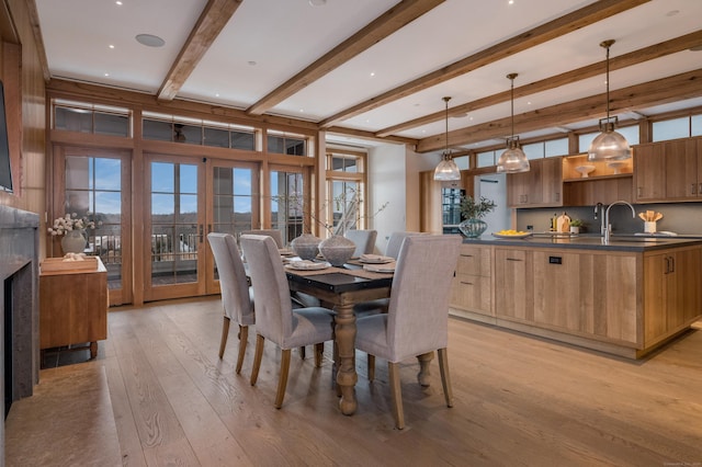 dining space featuring beam ceiling and light hardwood / wood-style flooring