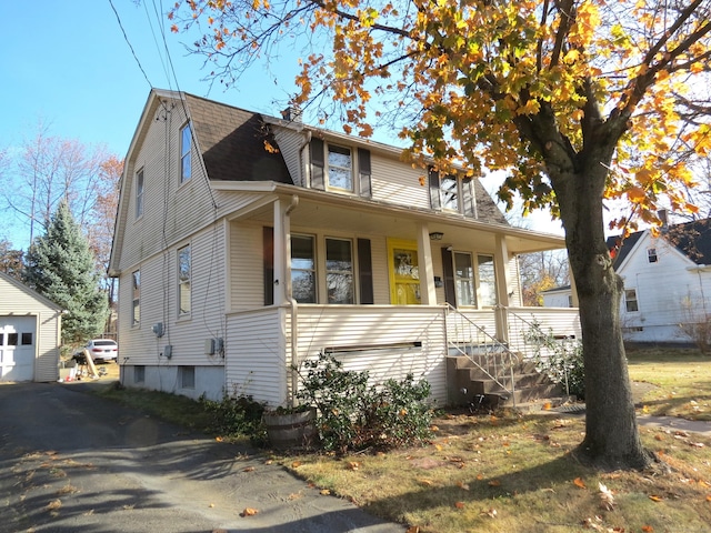 view of front of property with a garage, covered porch, and an outdoor structure