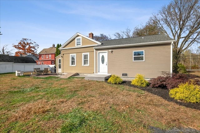 back of property featuring a patio and a lawn