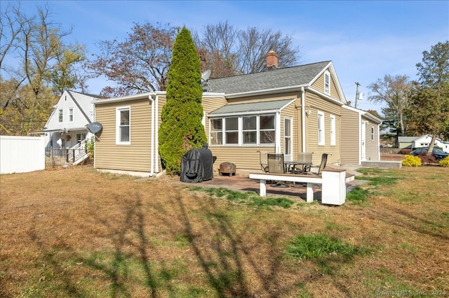 rear view of house featuring a yard