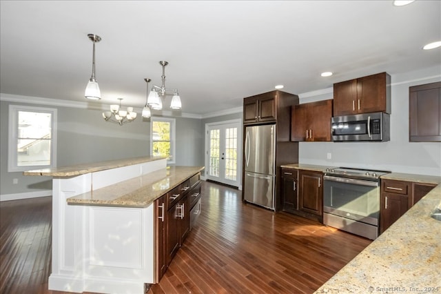 kitchen with dark hardwood / wood-style floors, a healthy amount of sunlight, stainless steel appliances, and hanging light fixtures