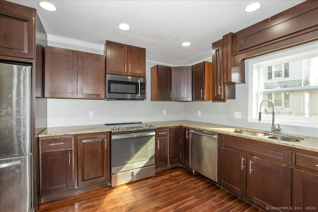 kitchen featuring sink, light stone counters, stainless steel appliances, crown molding, and dark hardwood / wood-style floors