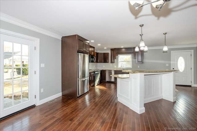 kitchen with light stone countertops, decorative light fixtures, stainless steel appliances, and dark hardwood / wood-style floors