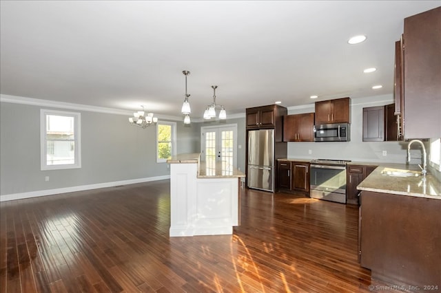 kitchen with a kitchen island, dark wood-type flooring, sink, a notable chandelier, and stainless steel appliances