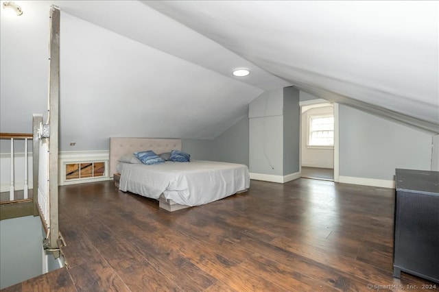 bedroom with vaulted ceiling and dark hardwood / wood-style floors