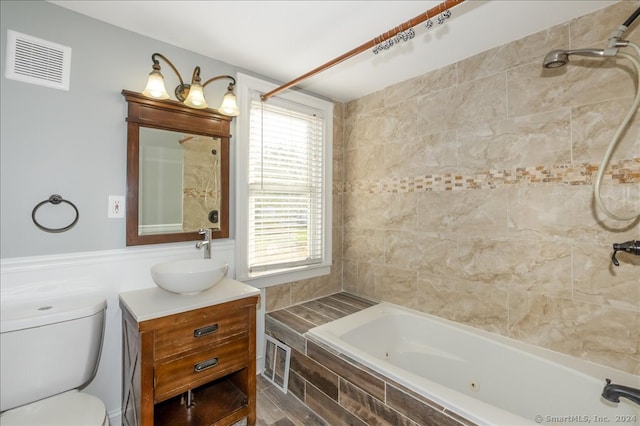 full bathroom with vanity, toilet, and tiled shower / bath