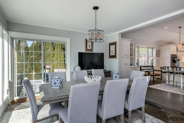 dining area with ornamental molding and a notable chandelier