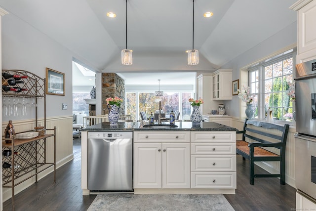 kitchen featuring stainless steel dishwasher, sink, pendant lighting, white cabinetry, and lofted ceiling