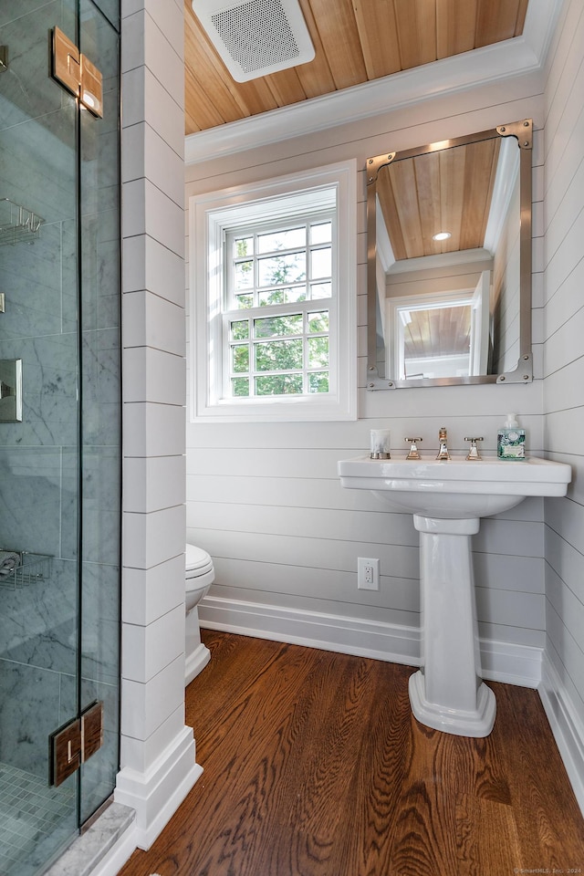 bathroom with wood walls, a shower with door, wooden ceiling, hardwood / wood-style flooring, and toilet