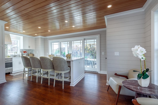 dining room with sink, dark hardwood / wood-style floors, and wood ceiling