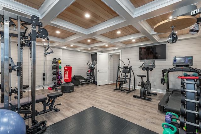 workout area with coffered ceiling, light hardwood / wood-style flooring, crown molding, wooden walls, and wood ceiling