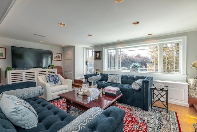 living room featuring light hardwood / wood-style flooring and ornamental molding