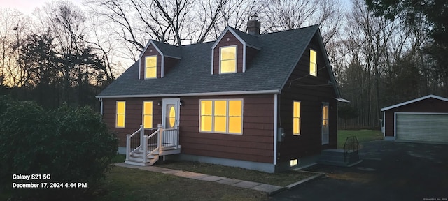 view of front of property with a garage, an outbuilding, and a shingled roof