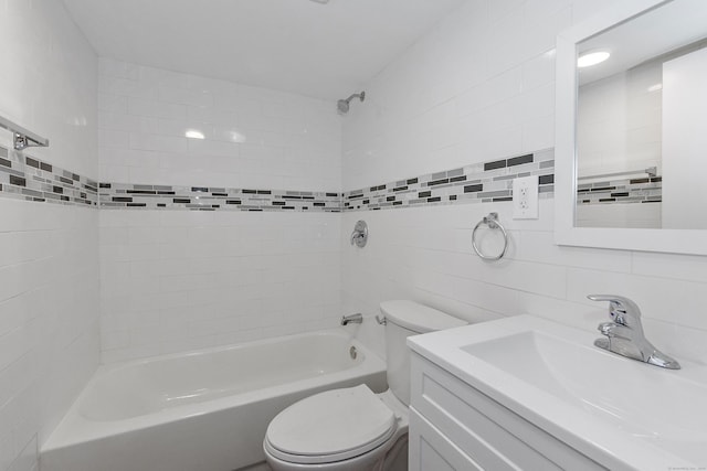 bathroom with vanity, toilet, tile walls, and shower / bathing tub combination